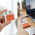 COLOUR:Orange - SSD enclosure connected by cable to a laptop on a desk