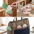 Soap sheet case open in a hand with a sheet being taken out