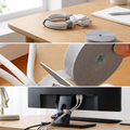 Cable winder tape wrapped around a bundled charging cable on a desk