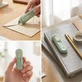 Mini paper cutter slicing open an envelope on a desk