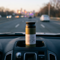 Grey insulated thermos bottle in a car cupholder