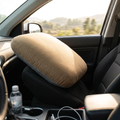 Brown memory foam neck pillow on a car seat headrest