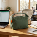 Green insulated lunch bag on an office desk beside a laptop